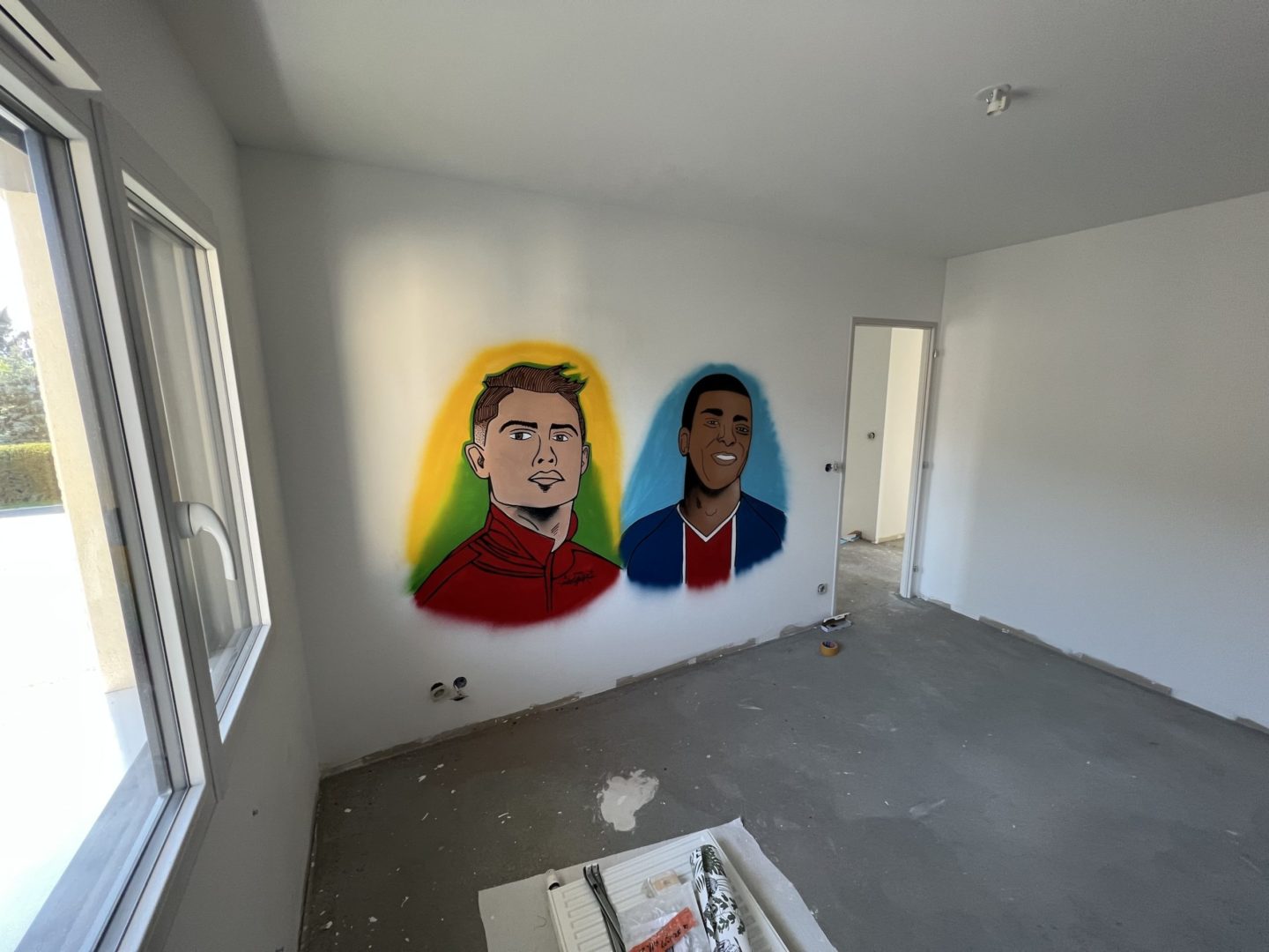 Réalisation d'une décoration graffiti d'une chambre d'enfant avec 2 portrait de footballeurs: cristiano ronaldo et kylian m. bappé par l'artiste Eazy One dans la région de Genève.